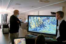 ECE Prof. Rick Johnson and Van Gogh Museum Head of Conservation Ella Hendriks observe a false color infrared digital image of Van Gogh’s Tree Trunks in the Grass captured by Lumiere Technology’s multi-spectral camera.